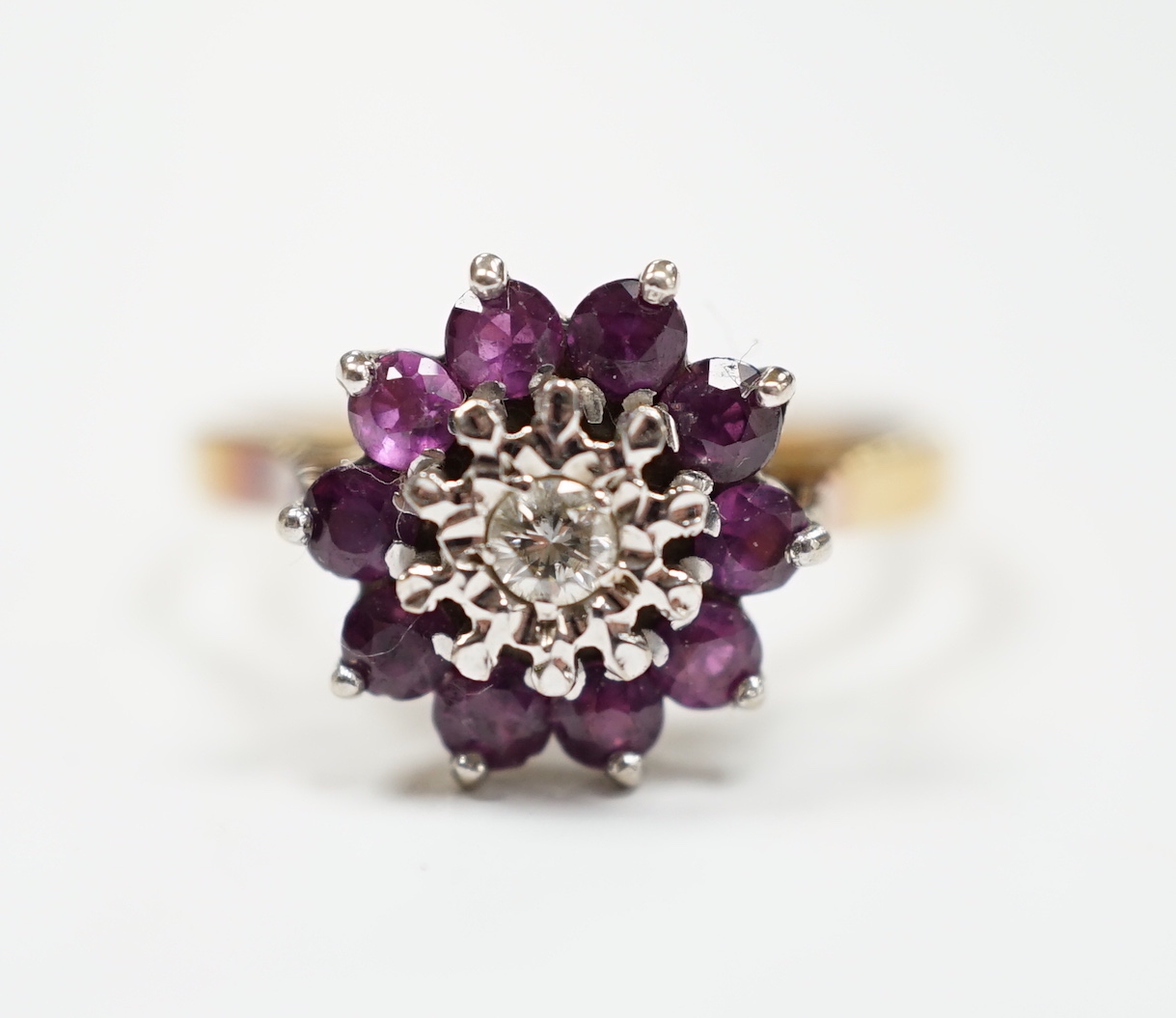 A modern 18ct gold, ruby and diamond cluster set flower head ring, size R, gross weight 4.2 grams.